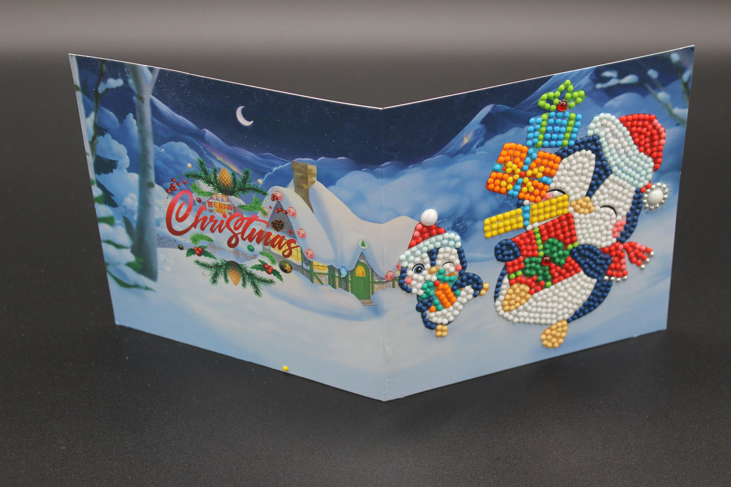 Two Cute Little Penguins Ice Skating with Presents. Card has Crystals and Gemstones.