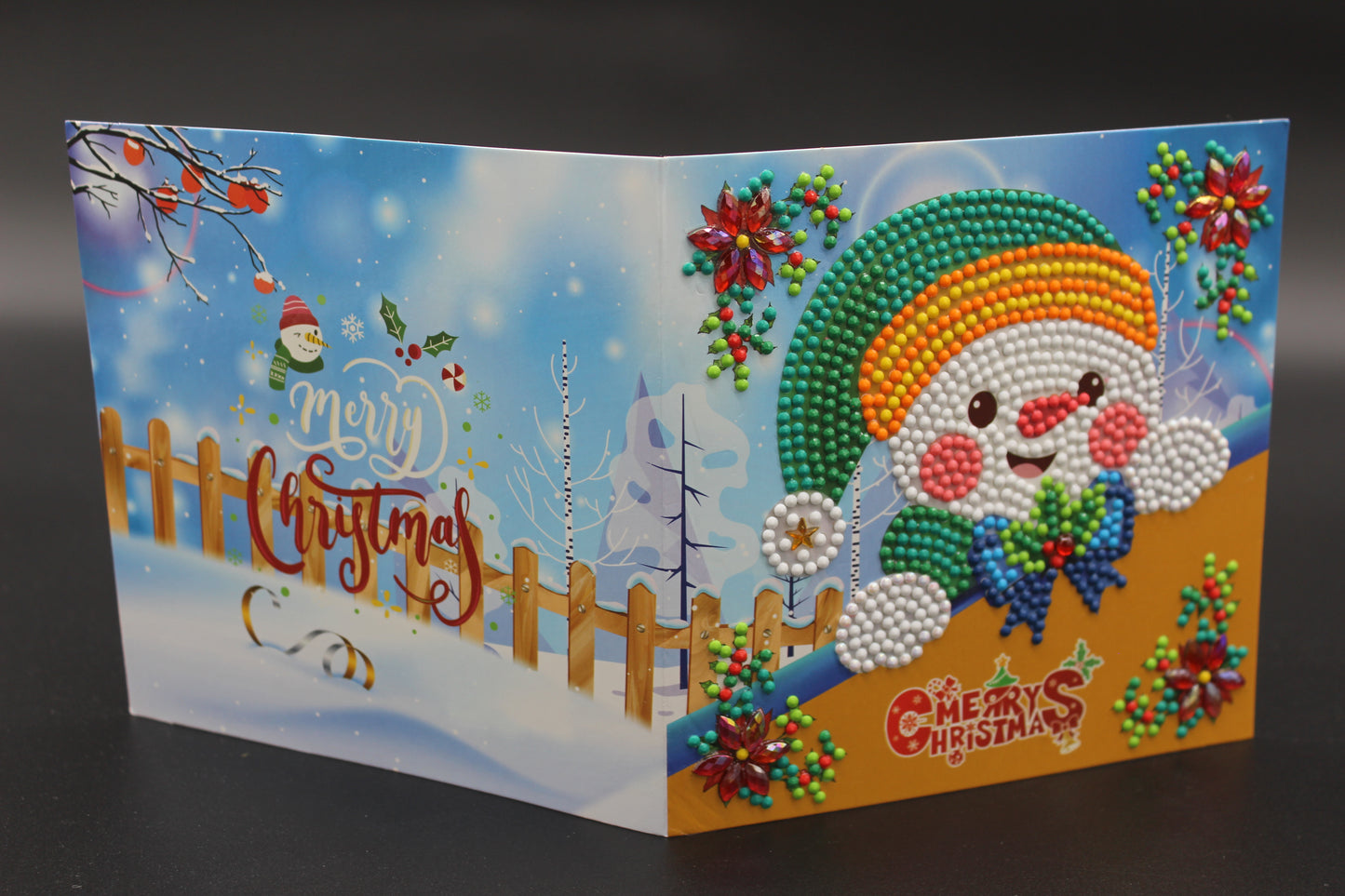 Mr. Snowman is Sitting Under a Beautiful Green, Fancy Decorated Christmas Tree and Red Poinsettias. Card has Crystals and Gemstones.