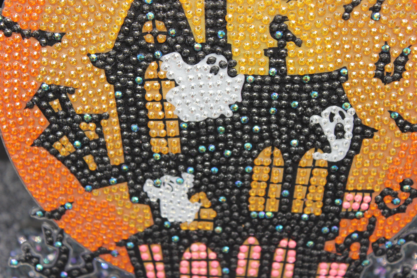 Halloween-themed design with a haunted house, ghosts, and pumpkins made of colorful beads.