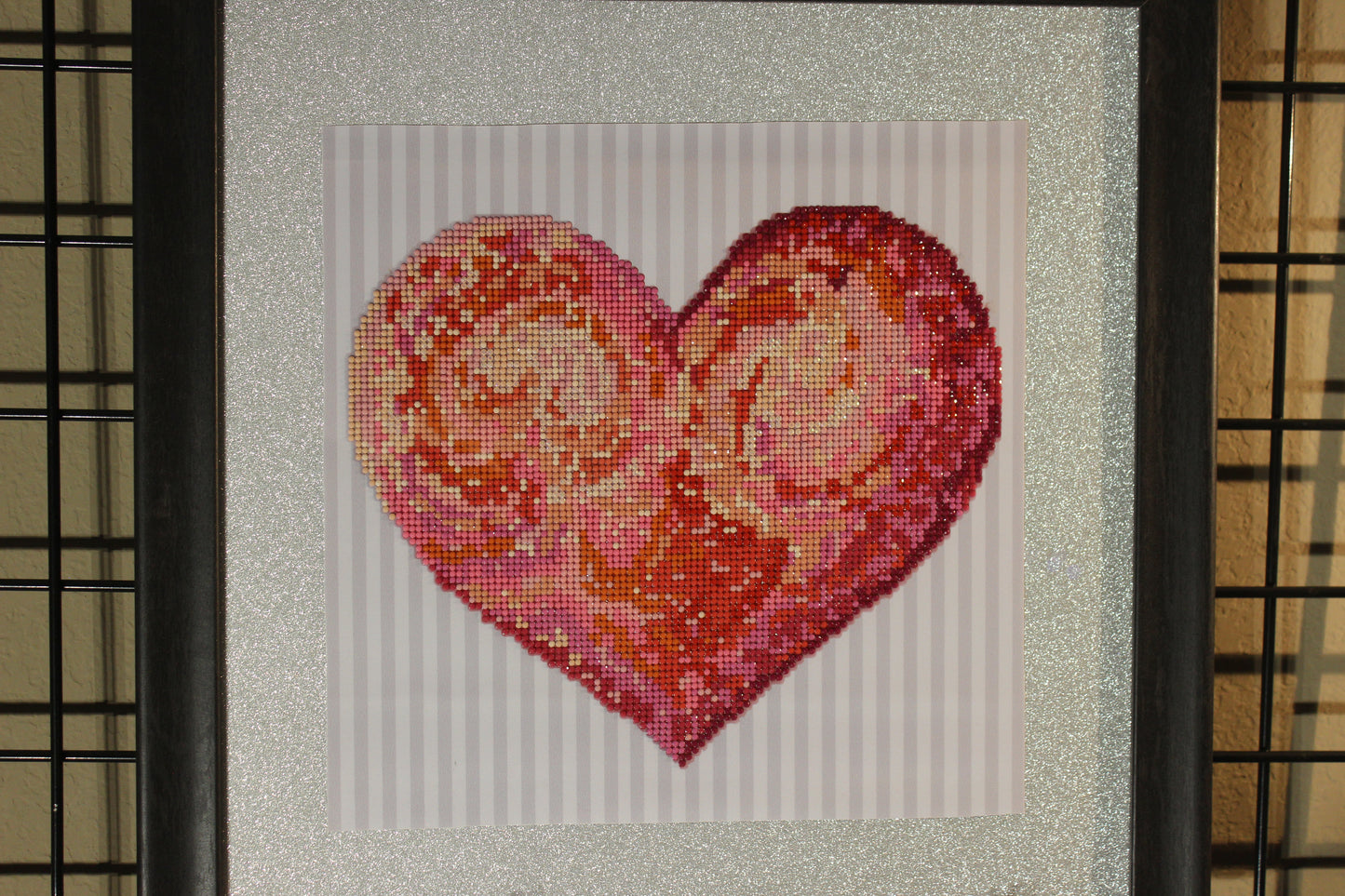 Diamond Art Painting with Colorful Hues of Red and Pink in a Single Large Heart with a Silver Background.