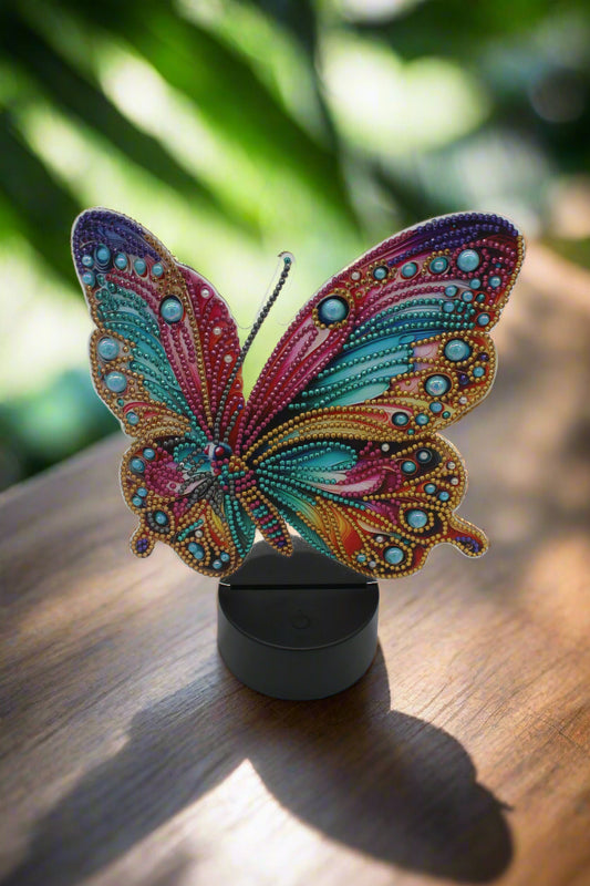 Colorful butterfly design on a black stand against a white background