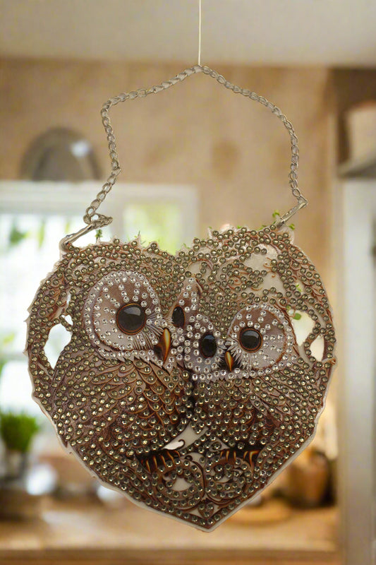 Decorative handbag with intricate designs and a chain strap on a beige background