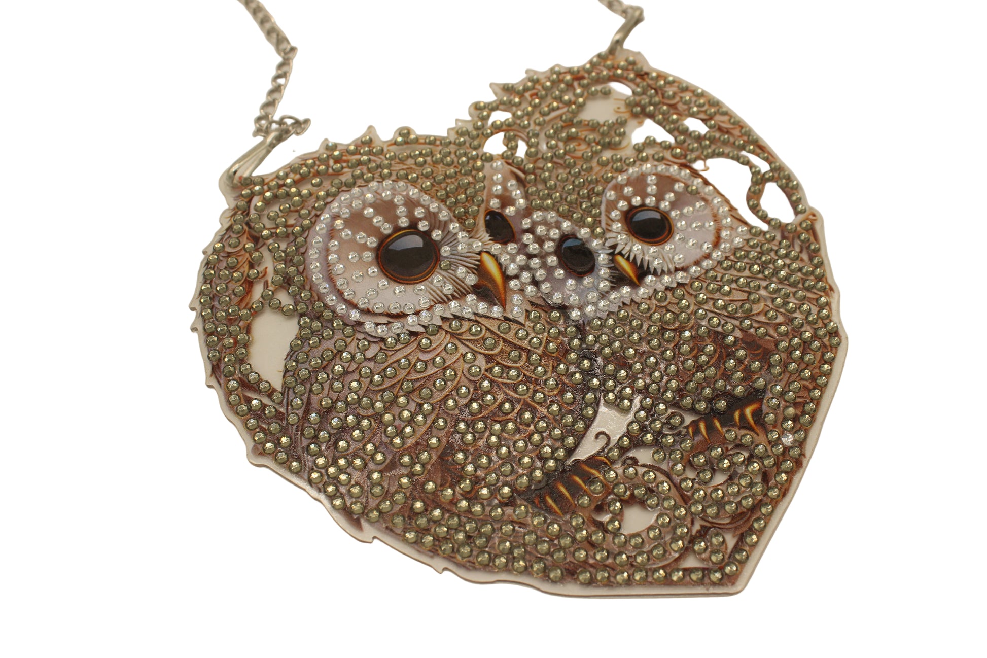 Decorative owl-shaped object with beaded details on a beige background