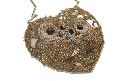 Decorative owl-shaped object with beaded details on a beige background