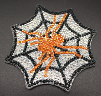 Spider web patch with orange spider on a gray background