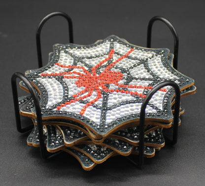 Set of four spiderweb-themed coasters in a metal holder on a dark background