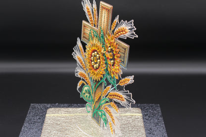 Decorative sunflower and wheat design on a stand against a black background