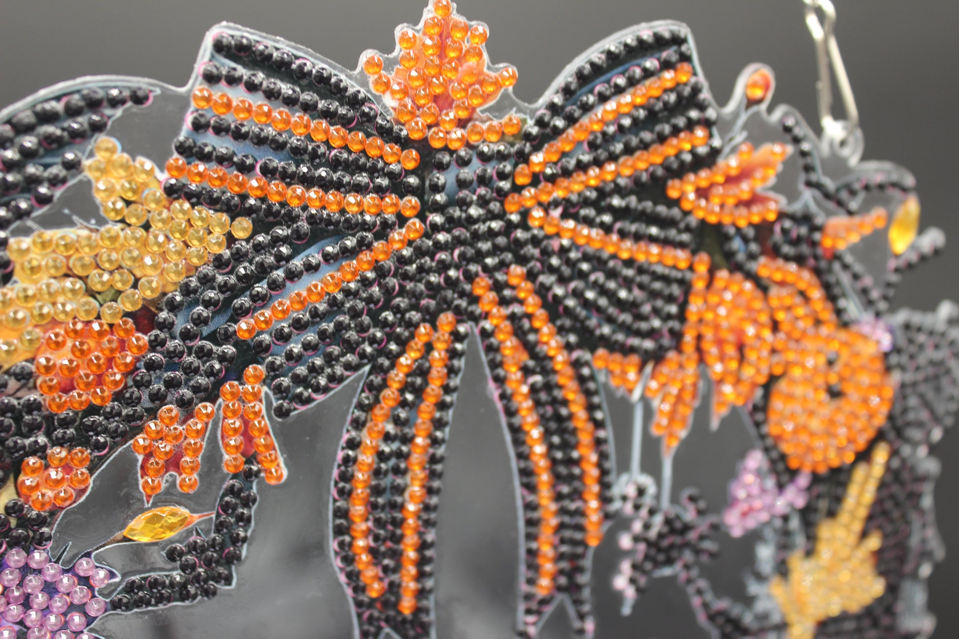 Beaded bow with orange, black, and yellow colors on a dark background