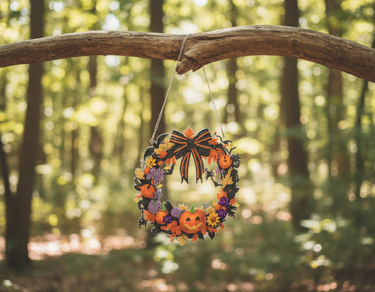 Decorative wreath with pumpkins and flowers hanging on a dark background
