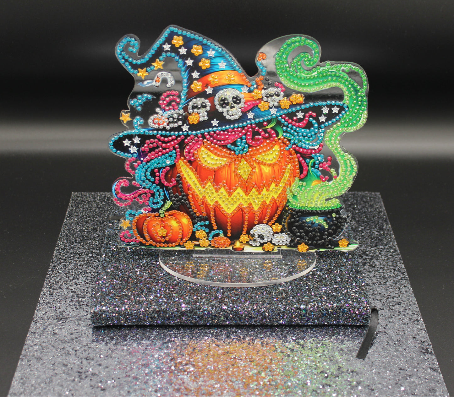 Colorful Halloween-themed decorative item on a black glittery surface