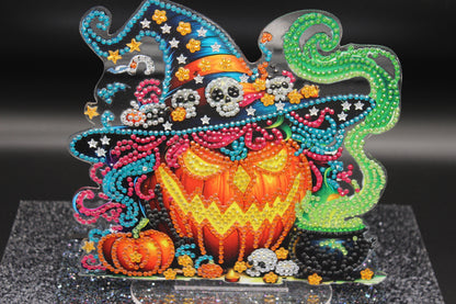 Decorative Halloween-themed craft with colorful beads and pumpkins on a black background