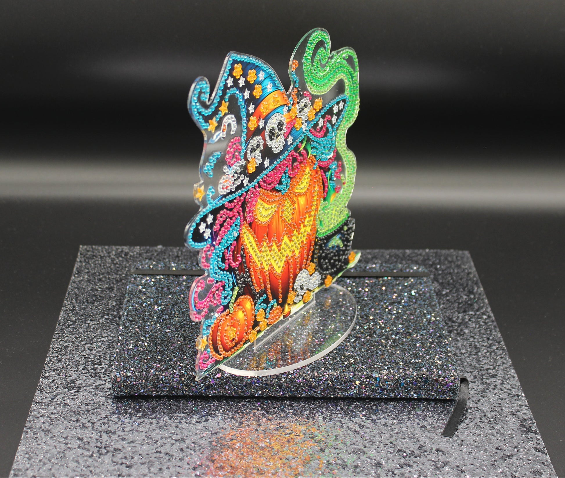 Colorful butterfly sculpture on a reflective surface with a dark background