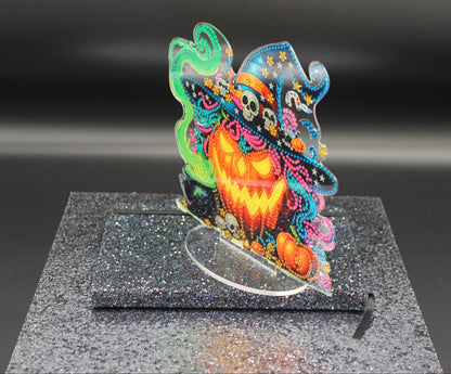 Colorful Halloween-themed decorative item on a black stand with a dark background