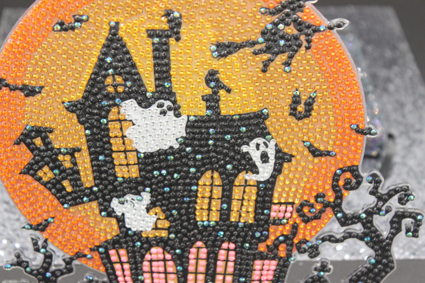Decorative patch with a haunted house, ghosts, and bats on an orange background.
