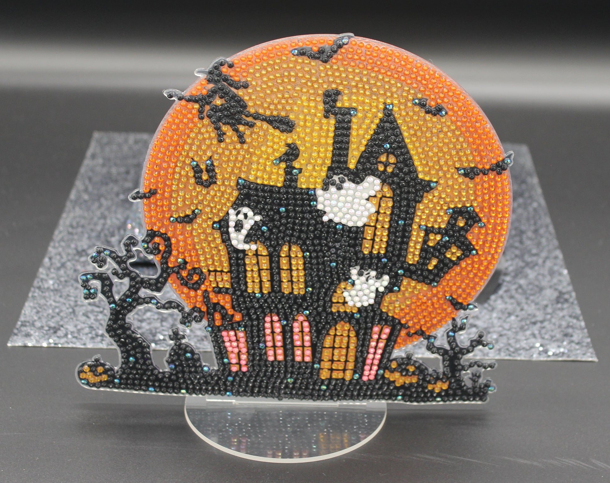 Halloween-themed beaded design with a castle, ghosts, and bats on an orange background.
