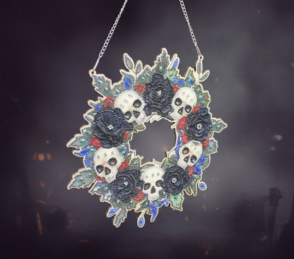 Decorative wreath with skulls and flowers on a black background