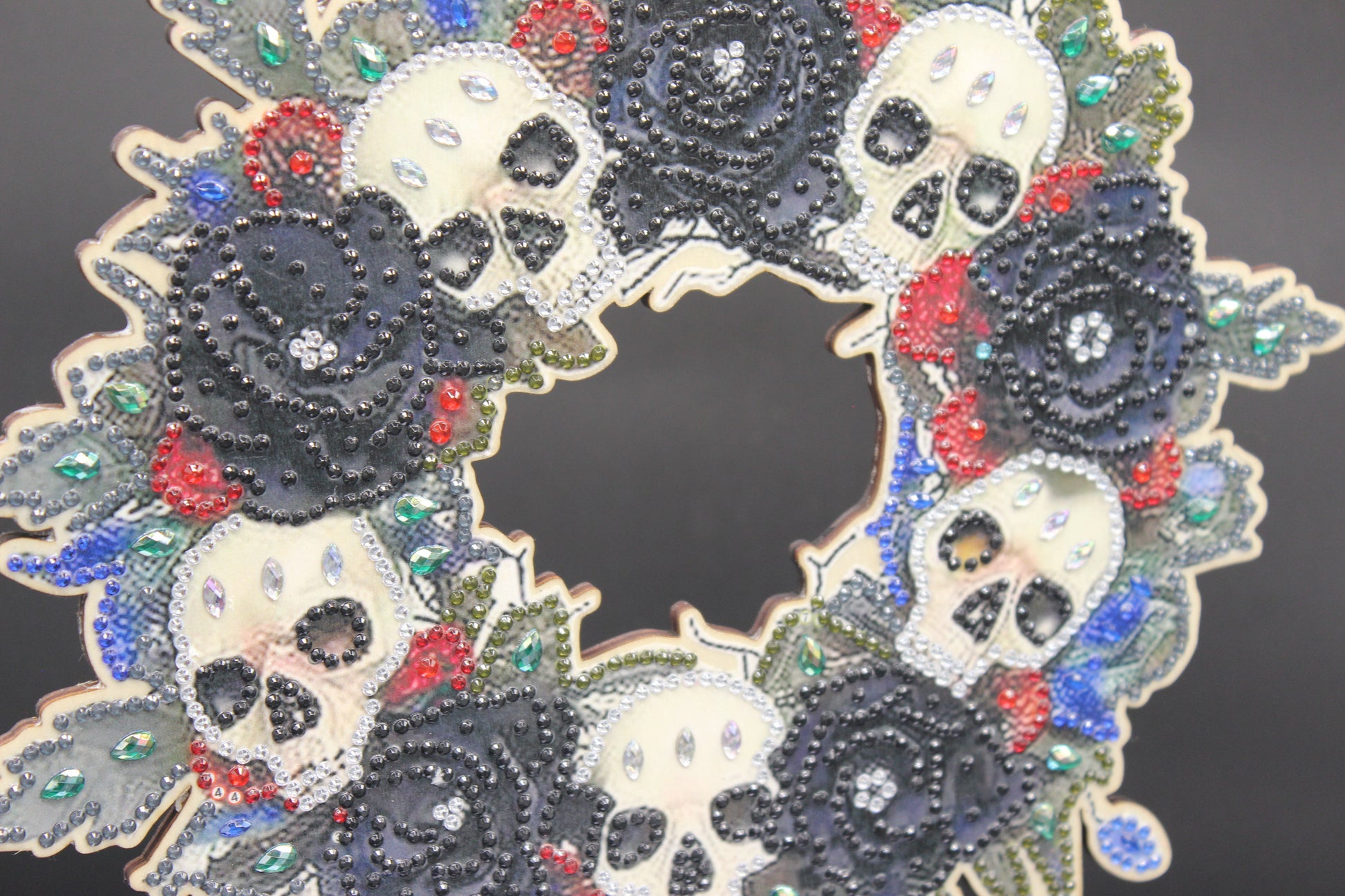 Decorative wreath with skulls and rhinestones on a dark background