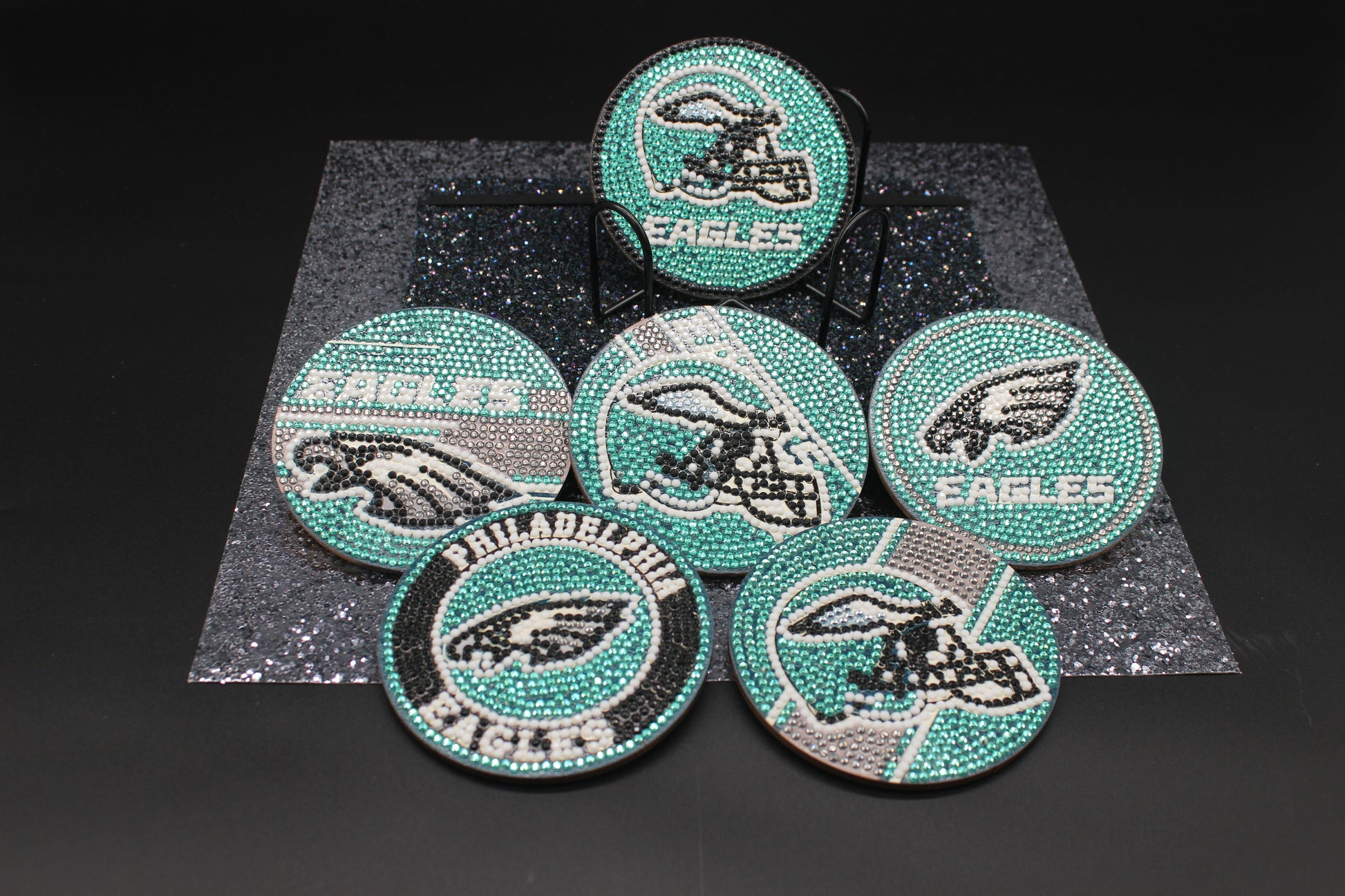 Set of Philadelphia Eagles-themed coasters with rhinestone embellishments on a dark background