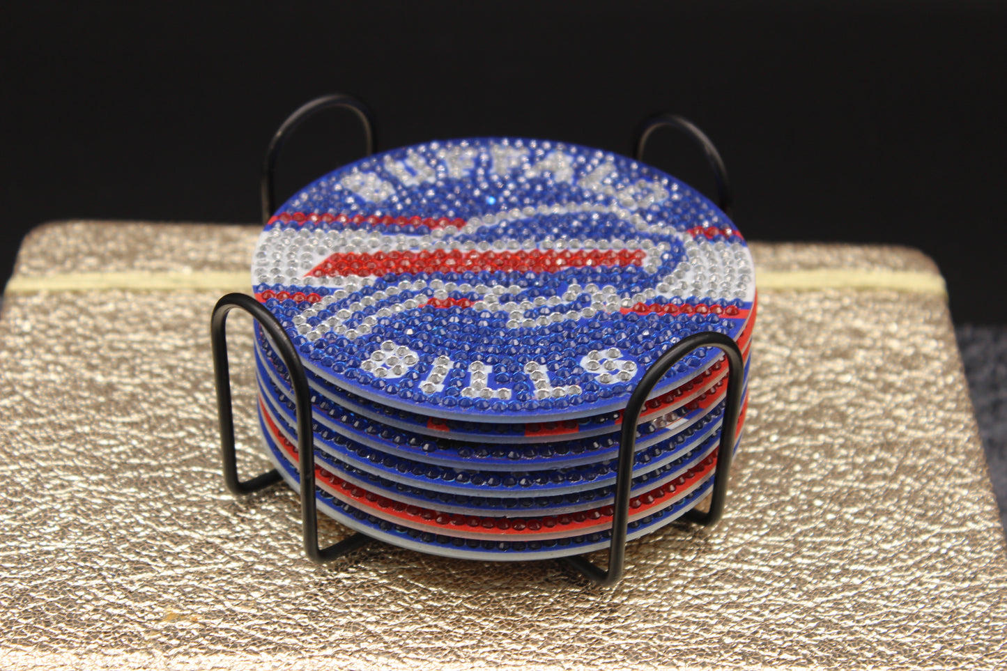 Stack of blue and red coasters with 'Bills' branding in a black holder on a textured surface.