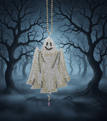 Decorative Halloween ornaments including a bat, ghost, and jack-o'-lantern on a dark background.