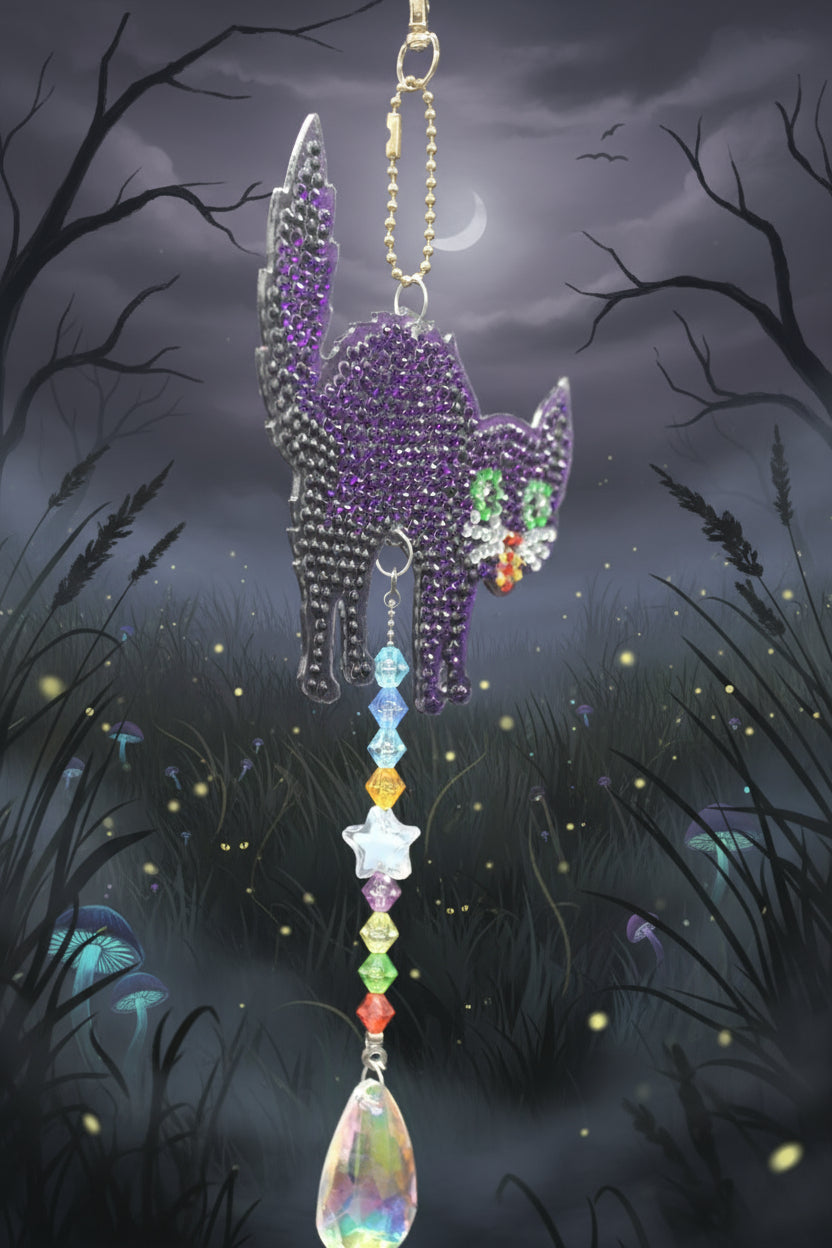 Decorative car charm with purple hand design and colorful beads on a dark background