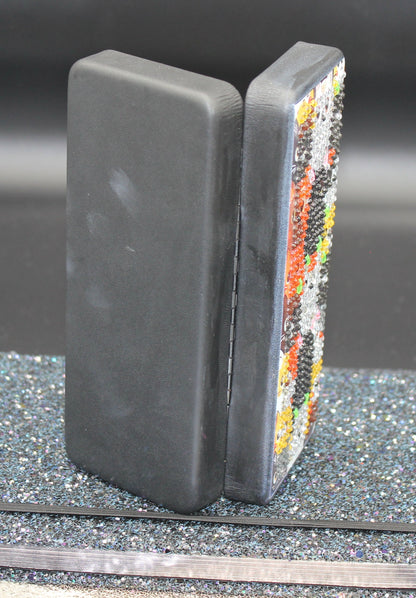 Two bookends with one featuring a colorful mosaic design on a gray surface.
