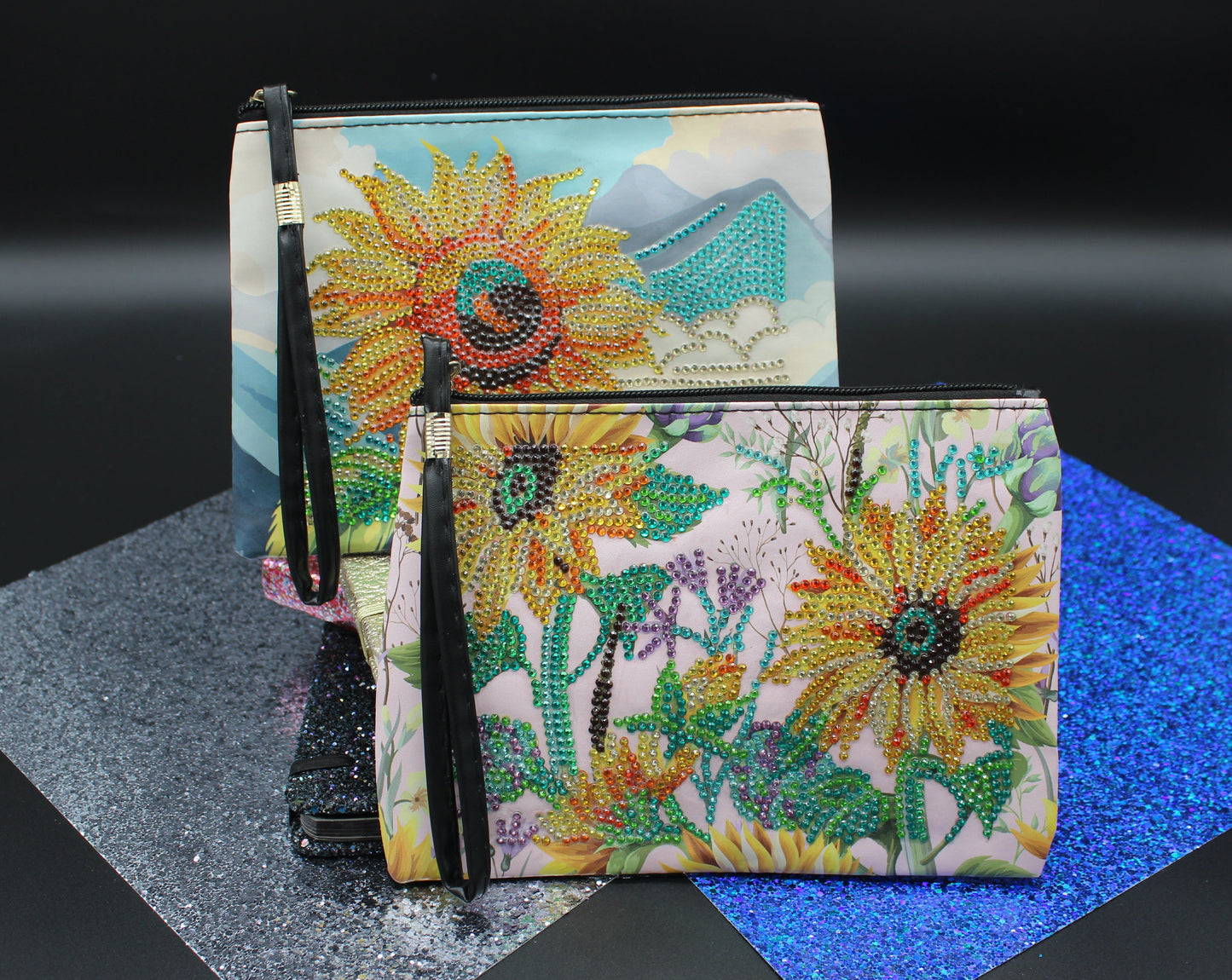 Two floral-patterned wallets on a dark surface with a blue textured mat.