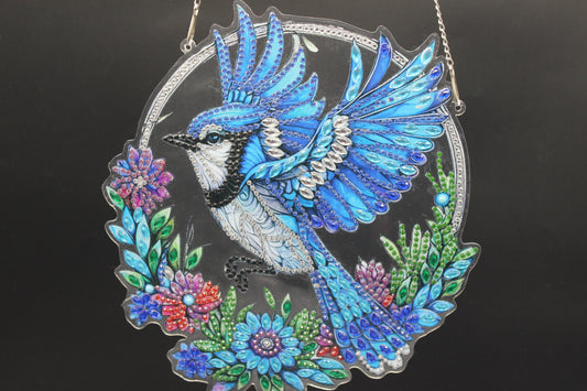 Multi Colored Suncatcher Diamond Art with a Blue Jay among Multi Colored Flowers